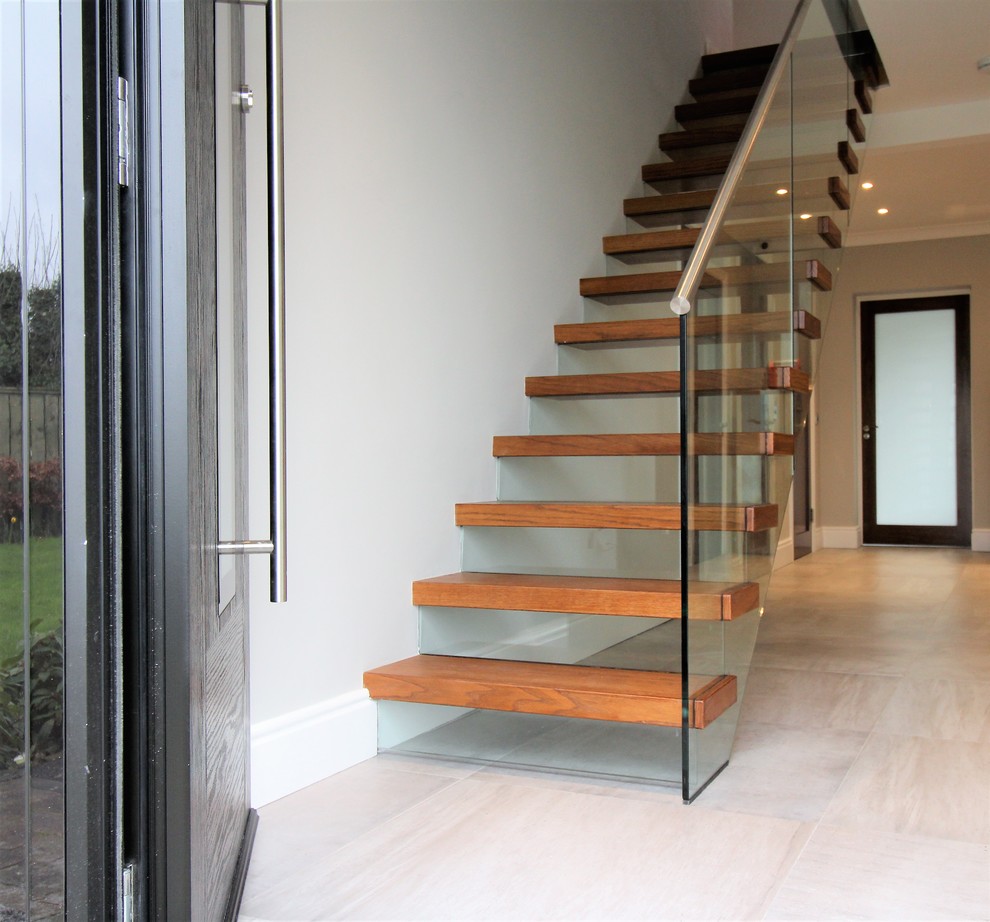 Foto de escalera recta minimalista de tamaño medio con escalones de madera y contrahuellas de vidrio