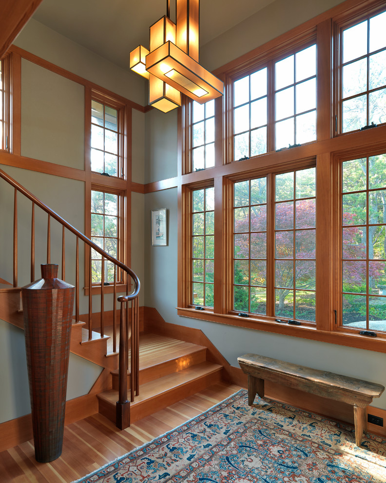 Ejemplo de escalera en L de estilo americano con escalones de madera, contrahuellas de madera y barandilla de madera