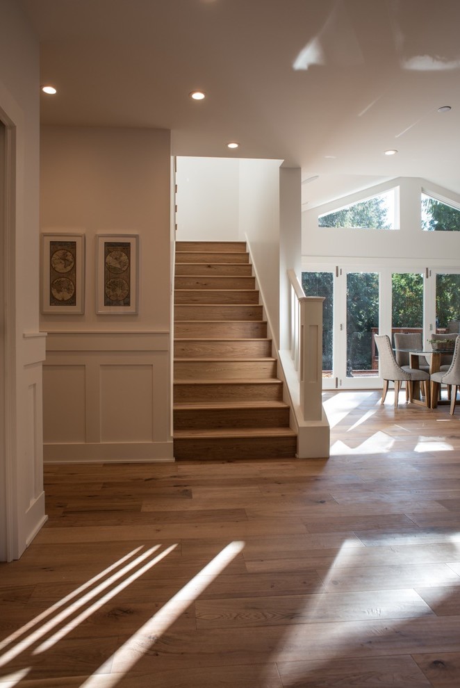 Ejemplo de escalera en U de estilo americano de tamaño medio con escalones de madera, contrahuellas de madera y barandilla de madera