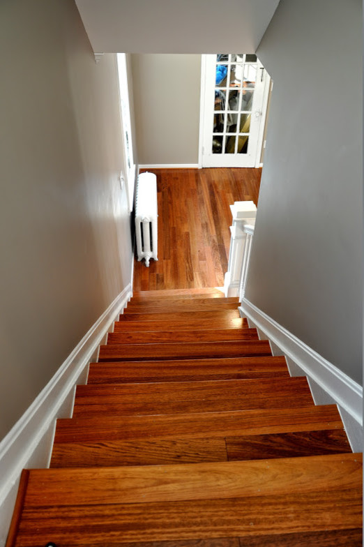Foto de escalera recta clásica de tamaño medio con escalones de madera, contrahuellas de madera y barandilla de madera