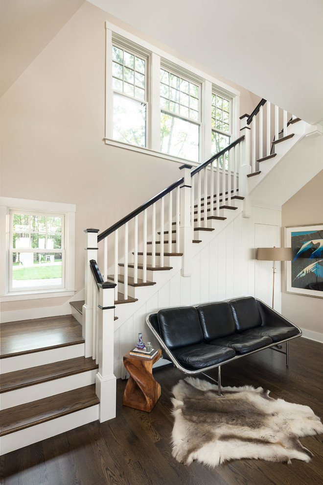 На фото: лестница в стиле неоклассика (современная классика) с деревянными ступенями, крашенными деревянными подступенками и кладовкой или шкафом под ней