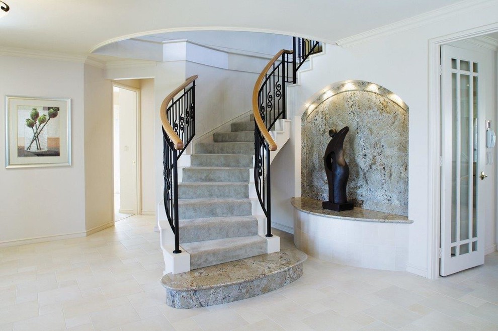 パースにある地中海スタイルのおしゃれな階段 (カーペット張りの蹴込み板、混合材の手すり) の写真