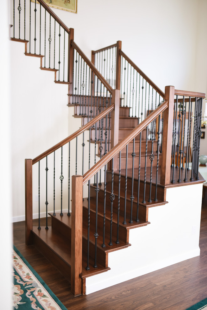Idée de décoration pour un escalier tradition en U de taille moyenne avec des marches en bois, des contremarches en bois et un garde-corps en métal.
