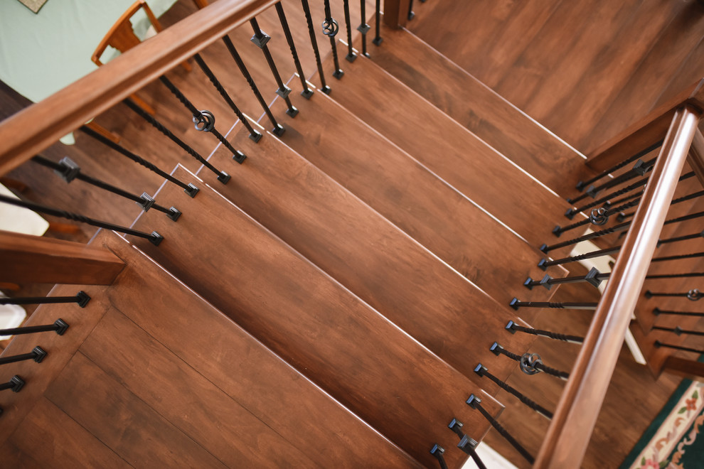 Réalisation d'un escalier tradition en U de taille moyenne avec des marches en bois, des contremarches en bois et un garde-corps en métal.