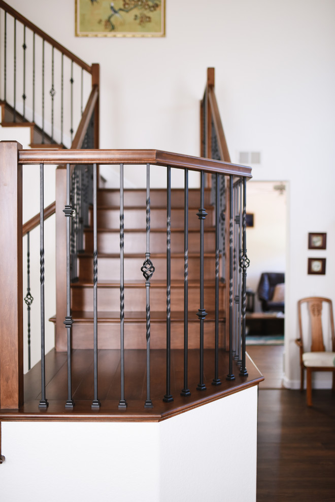 Aménagement d'un escalier classique en U de taille moyenne avec des marches en bois, des contremarches en bois et un garde-corps en métal.
