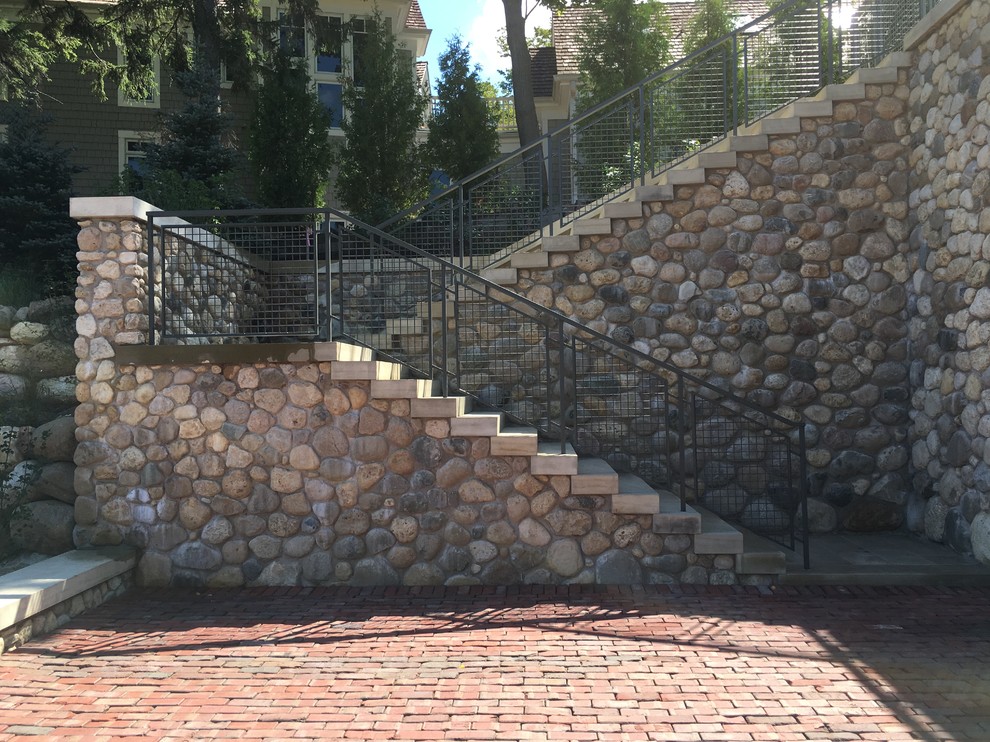 ミルウォーキーにあるラグジュアリーな巨大なトラディショナルスタイルのおしゃれな外階段 (コンクリートの蹴込み板、金属の手すり) の写真