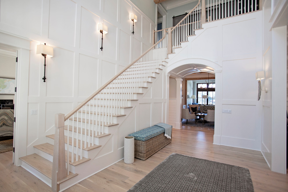 Стильный дизайн: большая угловая лестница в стиле неоклассика (современная классика) с деревянными ступенями и крашенными деревянными подступенками - последний тренд