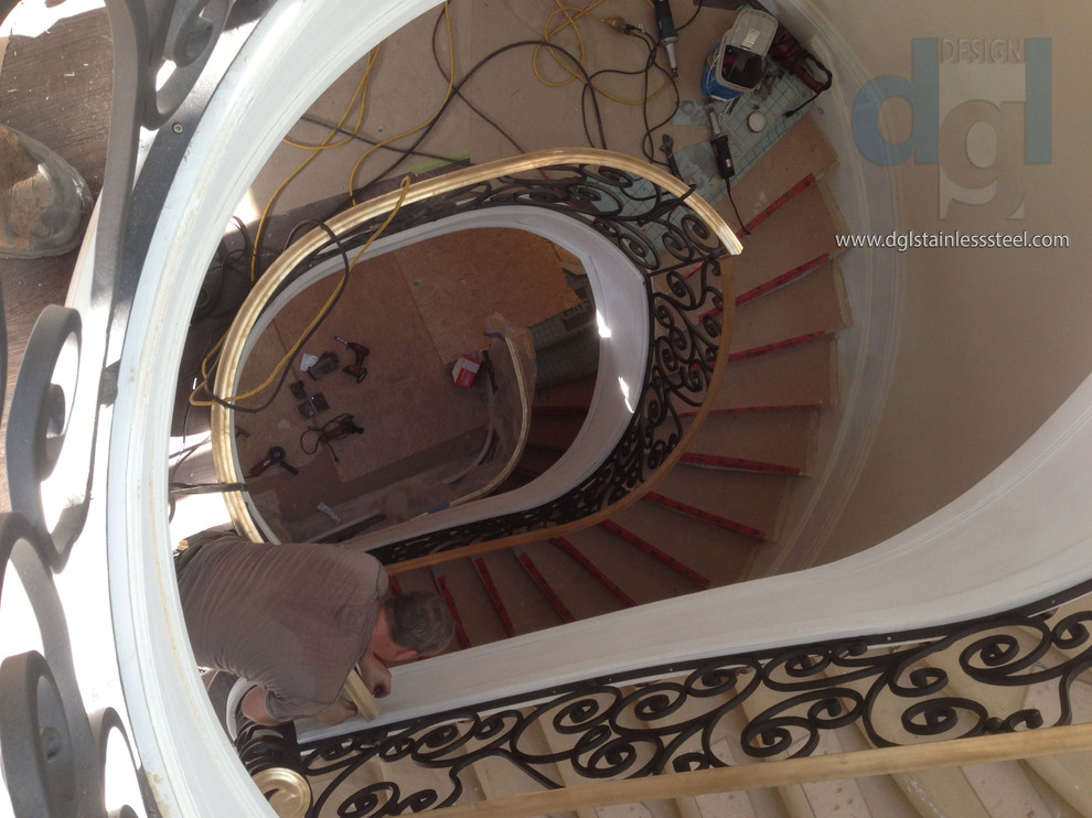 Idées déco pour un grand escalier courbe moderne en marbre avec des contremarches en marbre et un garde-corps en métal.