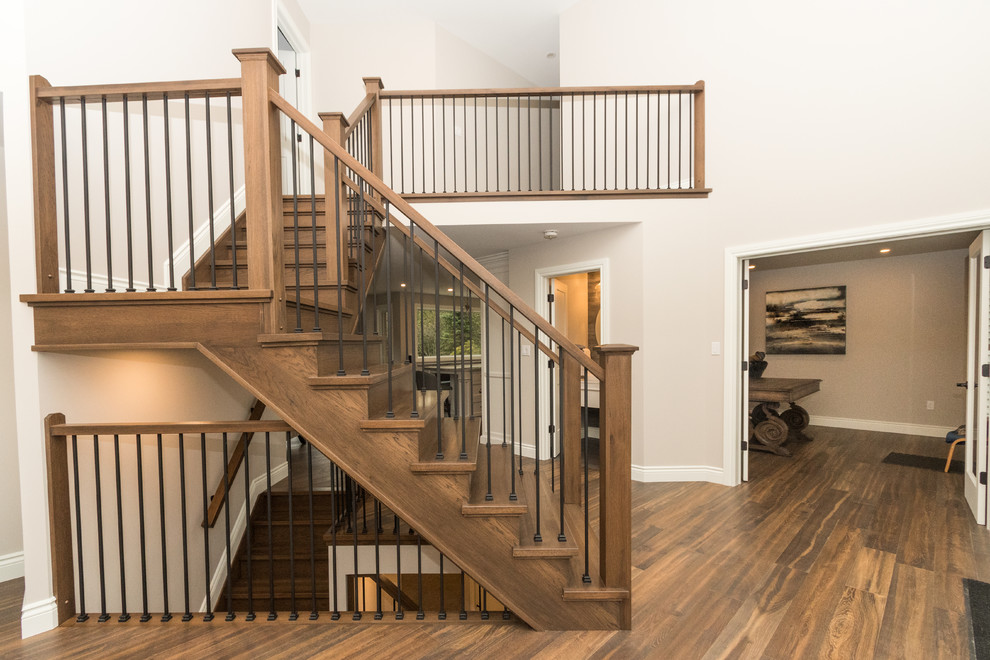 Foto de escalera en L clásica renovada de tamaño medio con escalones de madera, contrahuellas de madera y barandilla de madera