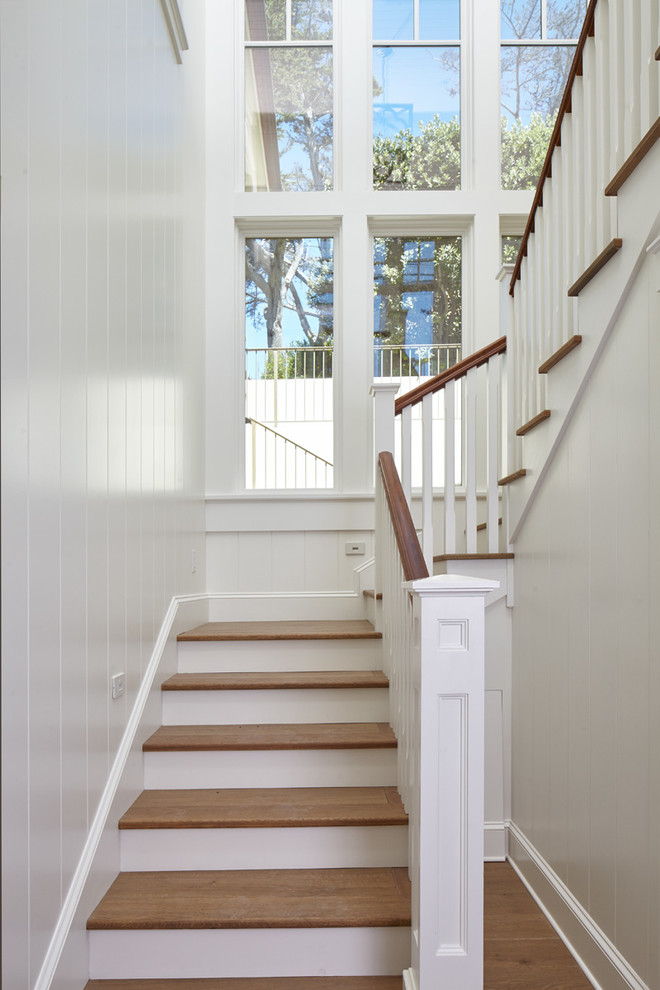 Свежая идея для дизайна: угловая лестница среднего размера в морском стиле с деревянными ступенями и крашенными деревянными подступенками - отличное фото интерьера