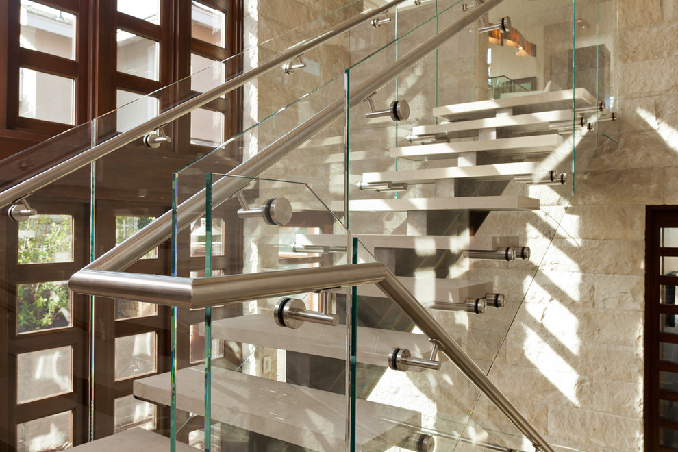 This is an example of a medium sized contemporary l-shaped staircase in San Francisco with open risers and limestone treads.