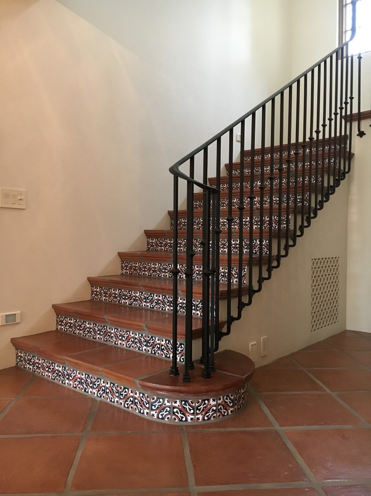 Example of a large tuscan tile u-shaped staircase design in San Francisco with tile risers