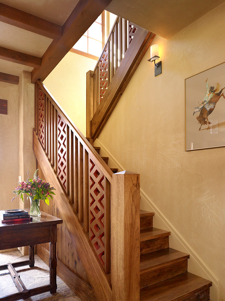 На фото: п-образная деревянная лестница в средиземноморском стиле с деревянными ступенями и деревянными перилами