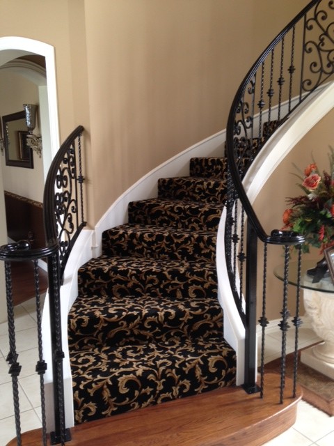 Свежая идея для дизайна: изогнутая лестница среднего размера в классическом стиле с ступенями с ковровым покрытием, ковровыми подступенками и металлическими перилами - отличное фото интерьера