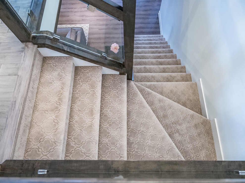 Свежая идея для дизайна: угловая лестница среднего размера в стиле шебби-шик с ступенями с ковровым покрытием, ковровыми подступенками и стеклянными перилами - отличное фото интерьера