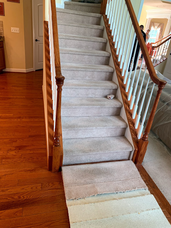 На фото: угловая деревянная лестница среднего размера в классическом стиле с ступенями с ковровым покрытием и деревянными перилами с