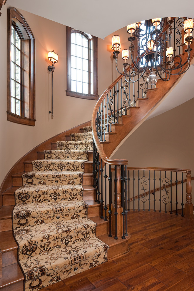 Large classic wood curved staircase in Indianapolis with wood risers.