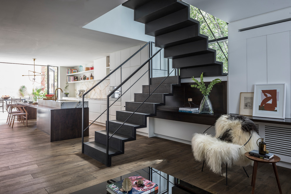 Inspiration pour un escalier flottant minimaliste de taille moyenne avec des marches en bois, un garde-corps en métal et éclairage.