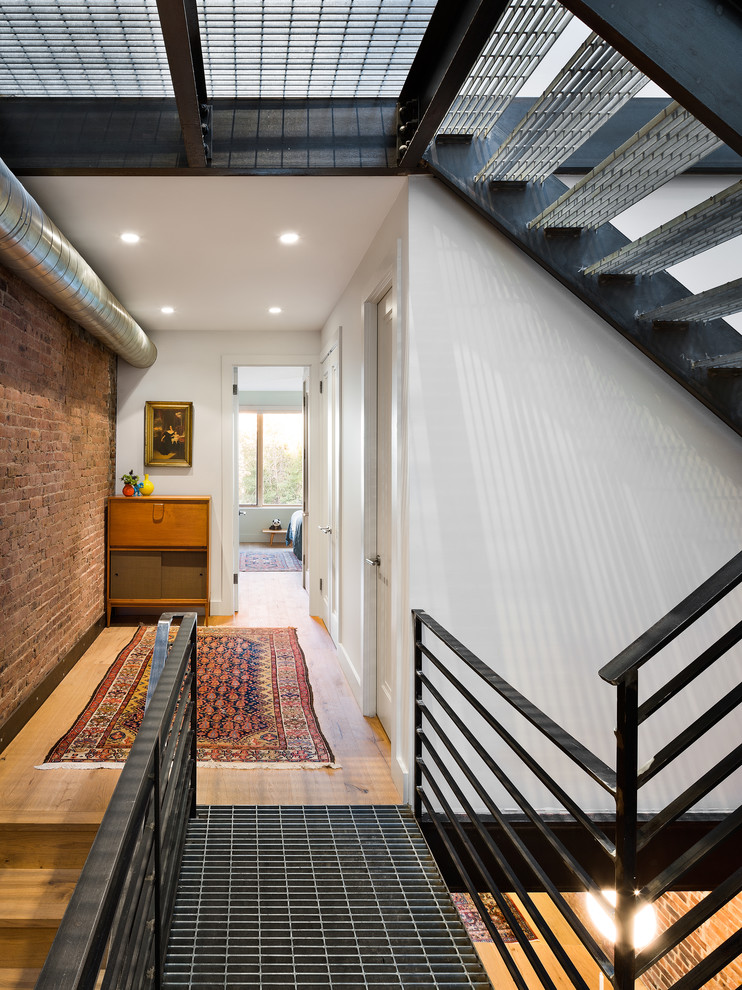 Example of a minimalist metal floating open and metal railing staircase design in New York