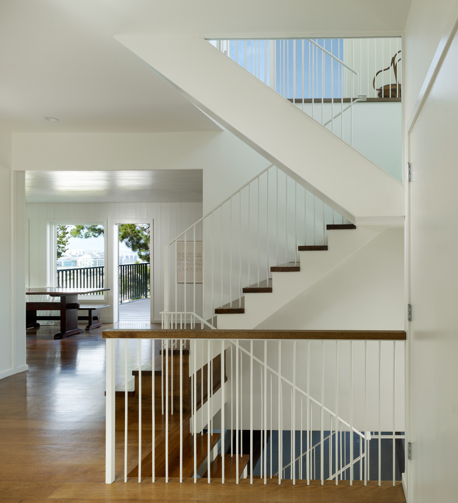 На фото: п-образная лестница в стиле неоклассика (современная классика) с деревянными ступенями с
