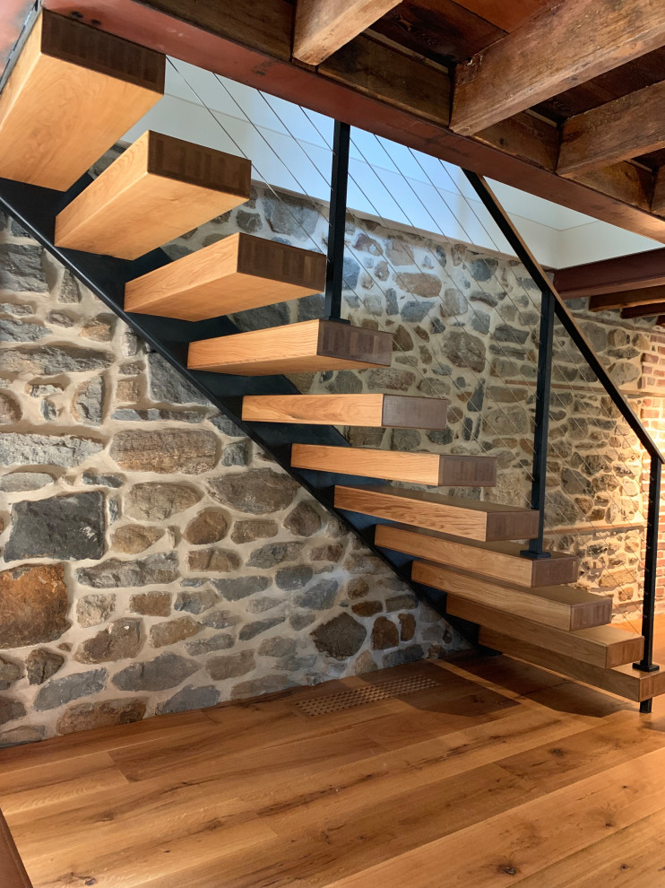 Cette photo montre un escalier nature avec des marches en bois et un garde-corps en câble.