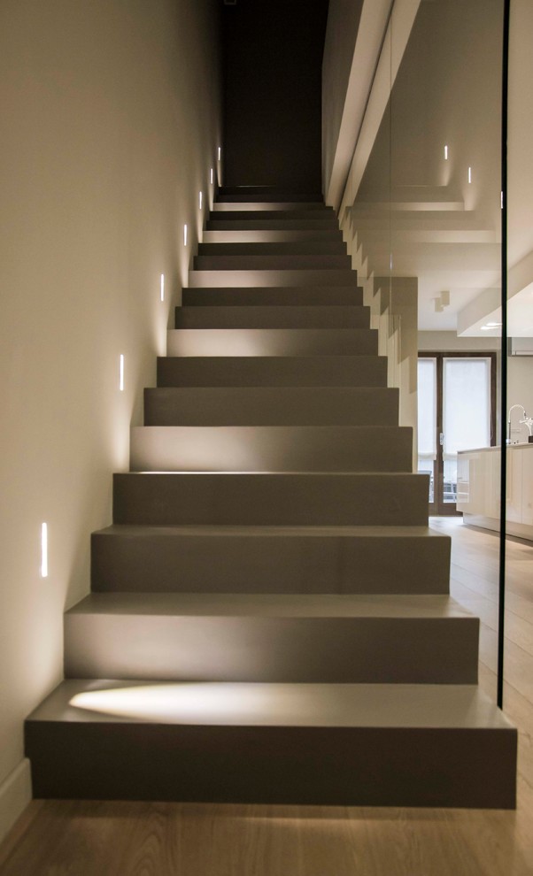 На фото: прямая бетонная лестница среднего размера в стиле модернизм с бетонными ступенями и стеклянными перилами с