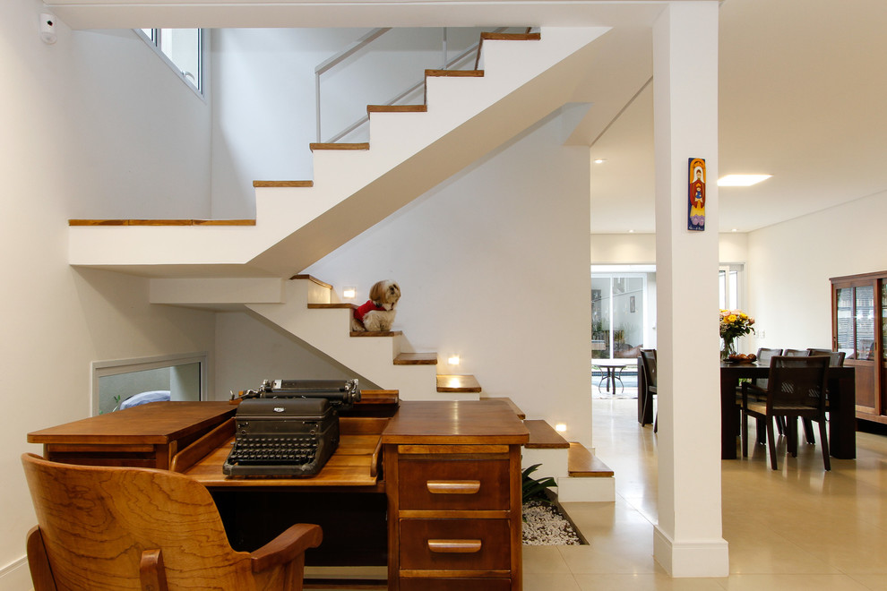 Ejemplo de escalera en U minimalista de tamaño medio con escalones de madera y contrahuellas de hormigón