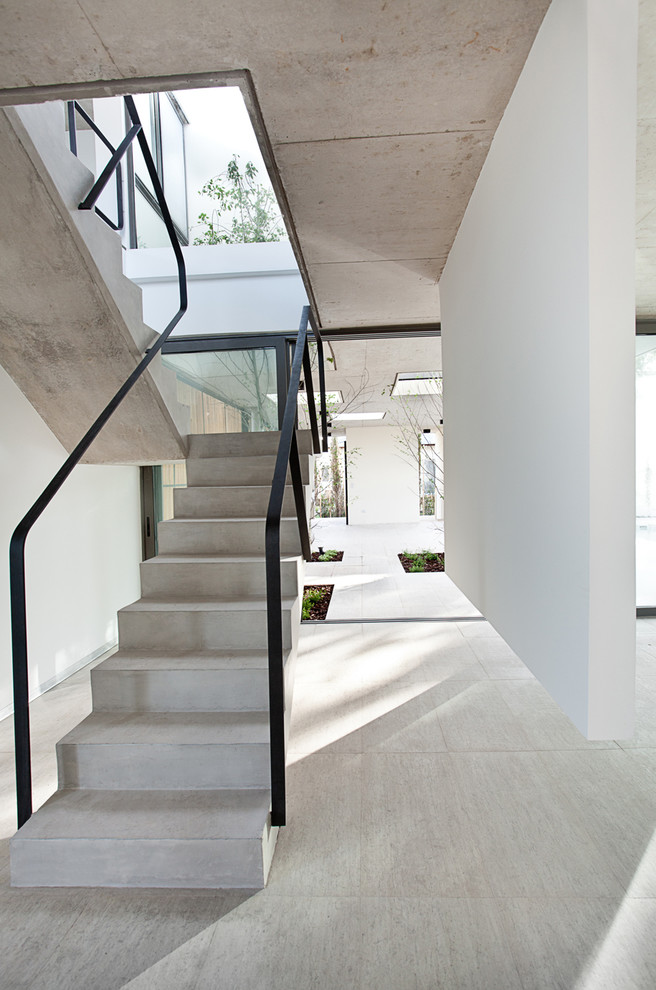 Cette image montre un escalier minimaliste en U et béton avec des contremarches en béton.