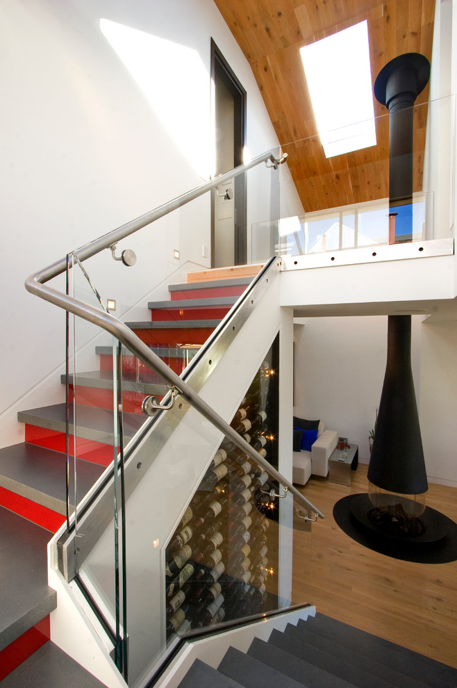 На фото: лестница в современном стиле с стеклянными перилами и кладовкой или шкафом под ней с