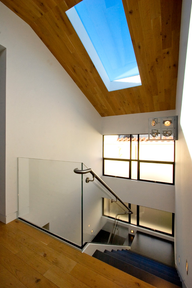 На фото: лестница в современном стиле с стеклянными перилами