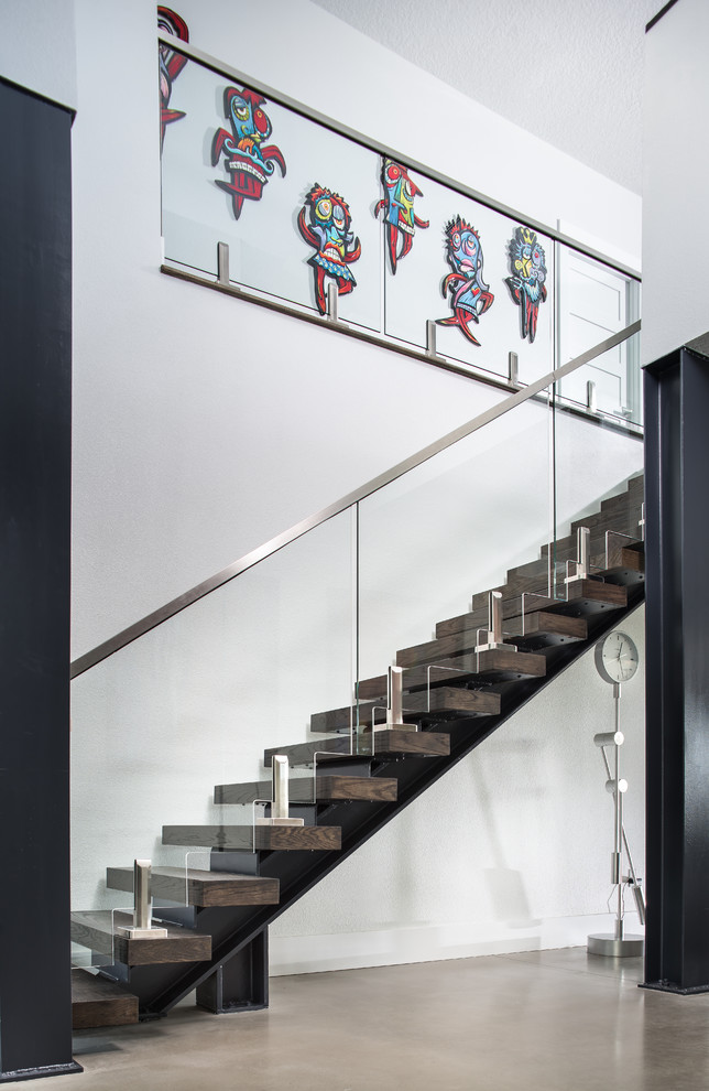 Пример оригинального дизайна: лестница в стиле лофт с деревянными ступенями и стеклянными перилами без подступенок