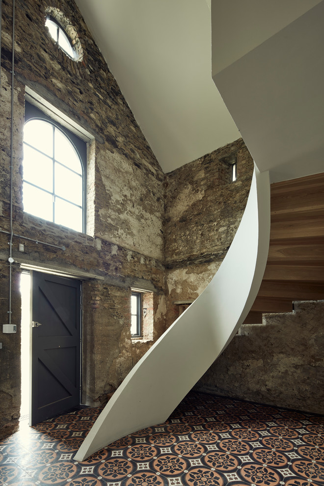 Réalisation d'un escalier courbe urbain avec des marches en bois et des contremarches en bois.