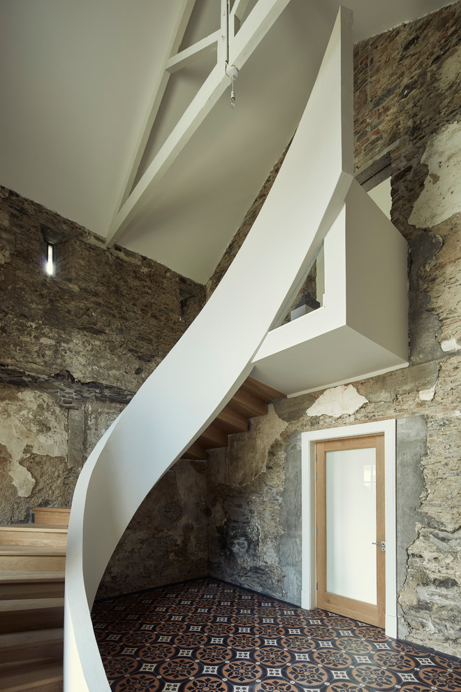 Пример оригинального дизайна: изогнутая деревянная лестница в стиле лофт с деревянными ступенями