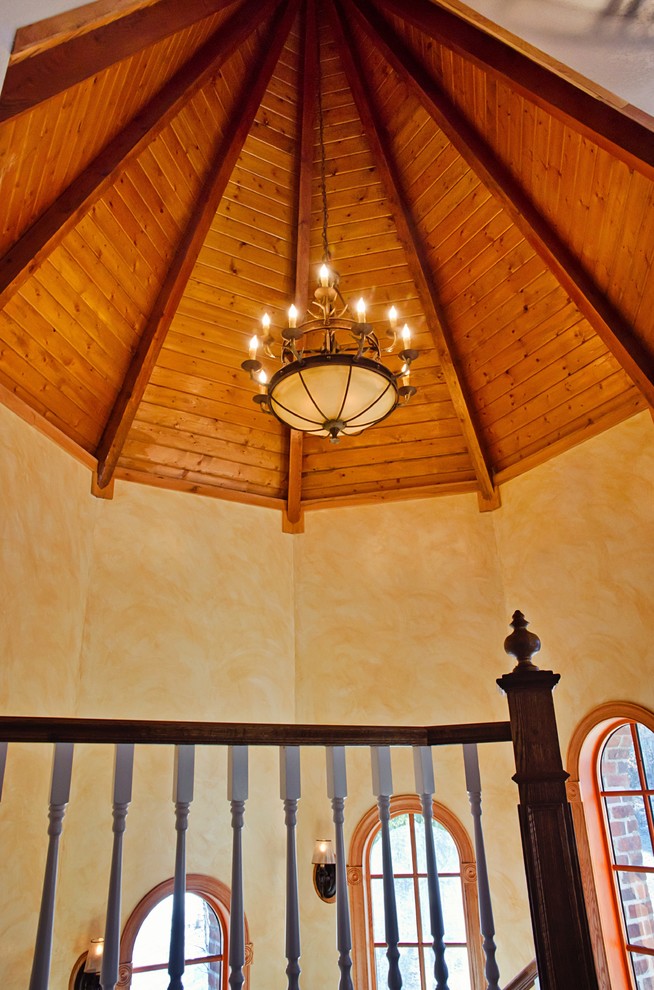 На фото: изогнутая деревянная лестница среднего размера в классическом стиле с деревянными ступенями и деревянными перилами