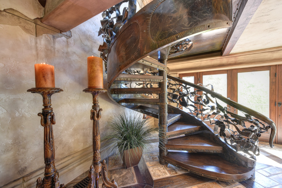 Стильный дизайн: огромная винтовая лестница в средиземноморском стиле с деревянными ступенями - последний тренд