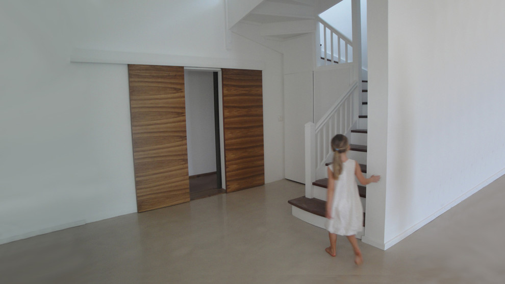 Foto de escalera en U clásica de tamaño medio con escalones de hormigón y contrahuellas de madera
