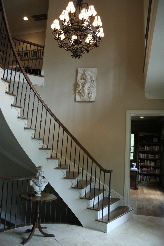 Пример оригинального дизайна: большая изогнутая металлическая лестница в классическом стиле с деревянными ступенями