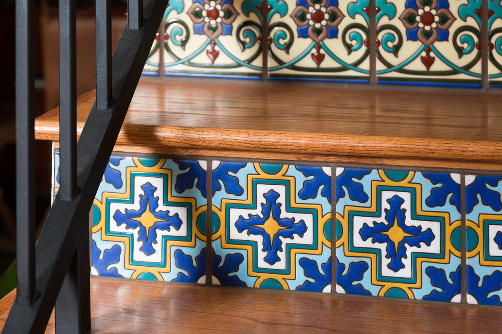 Ejemplo de escalera recta mediterránea de tamaño medio con escalones de madera, contrahuellas con baldosas y/o azulejos y barandilla de metal