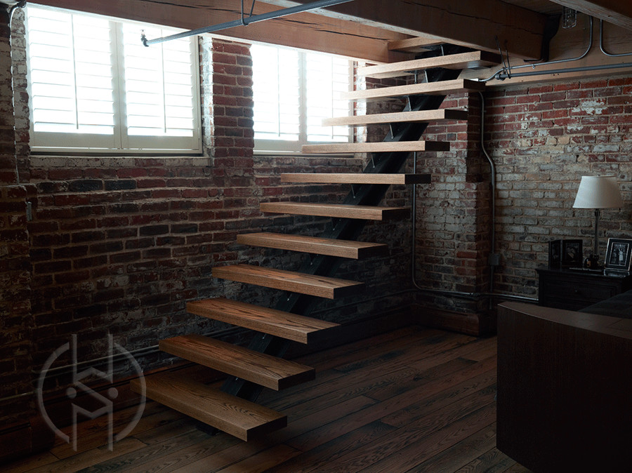 На фото: металлическая лестница на больцах в стиле модернизм с деревянными ступенями с
