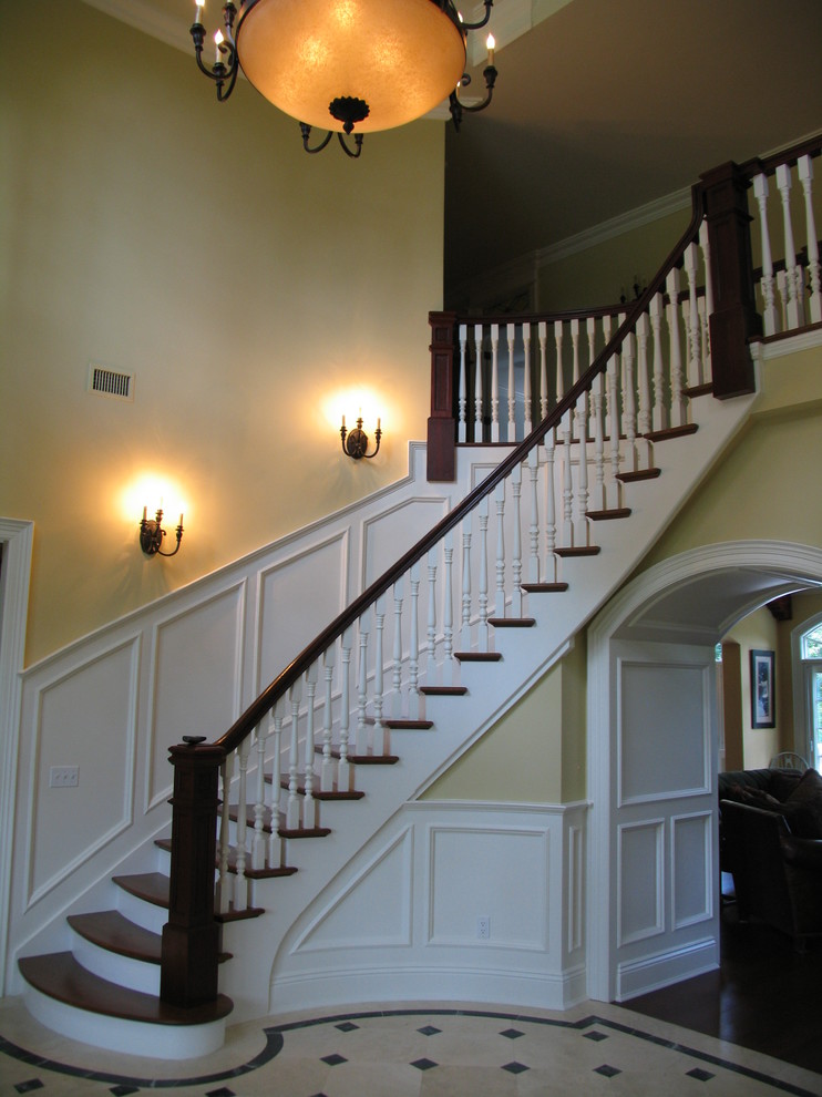 Foto de escalera curva clásica de tamaño medio con escalones de madera y contrahuellas de madera