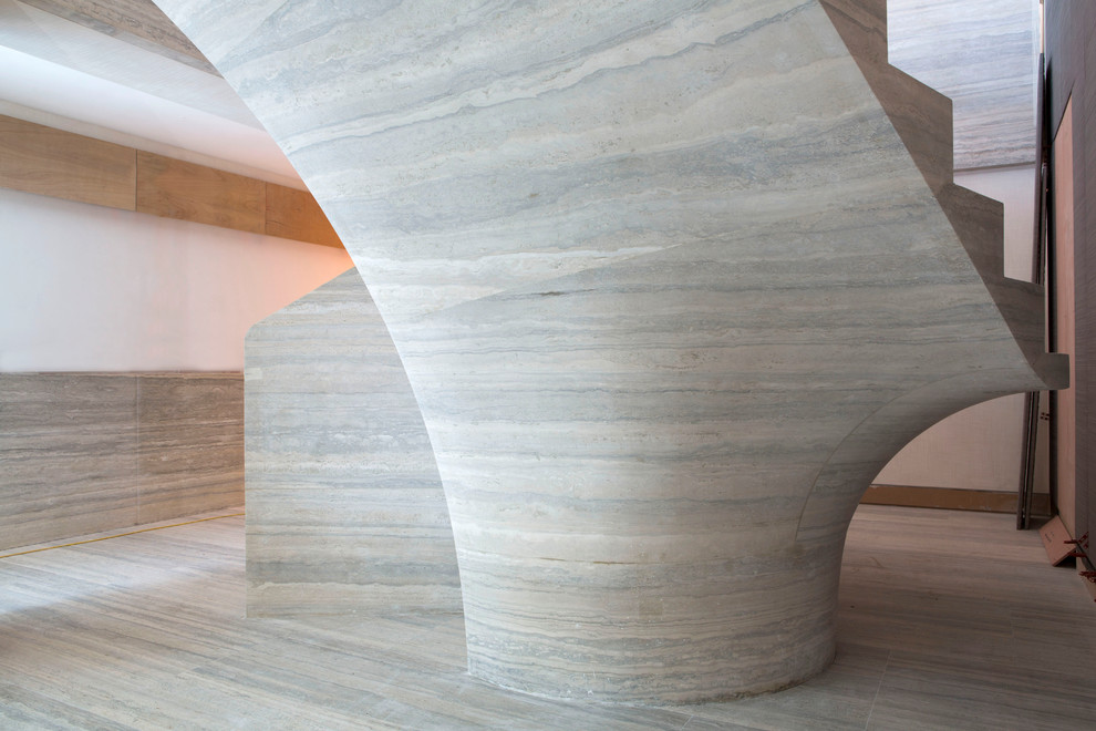Foto de escalera curva contemporánea extra grande con escalones de piedra caliza y contrahuellas de piedra caliza
