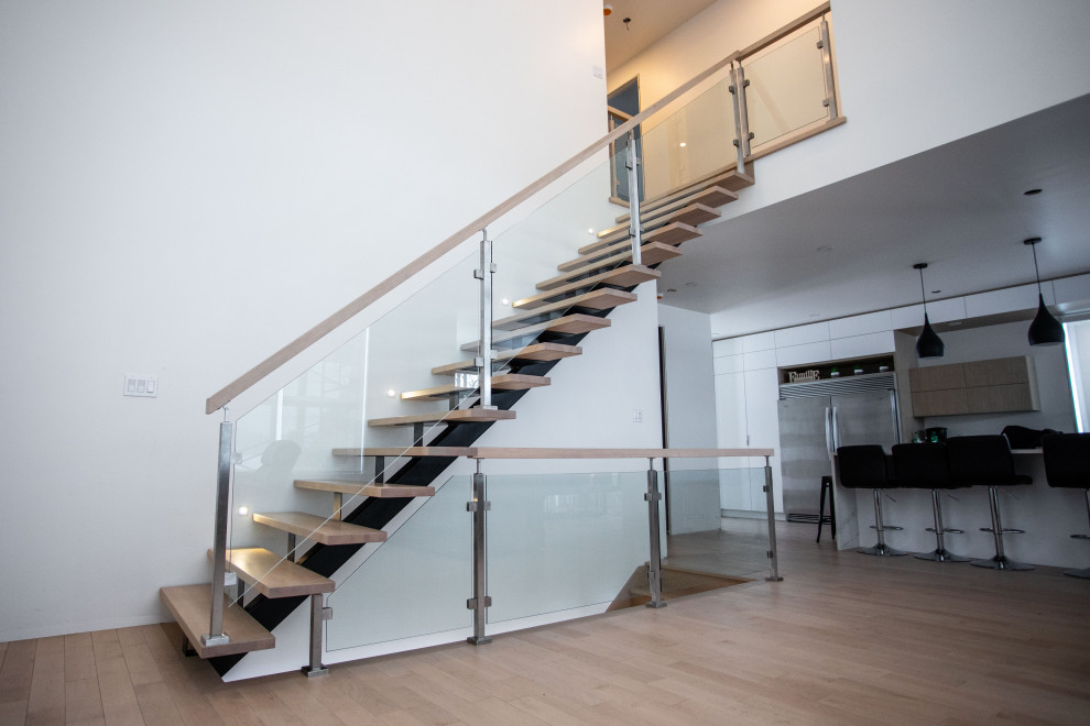Ejemplo de escalera recta moderna sin contrahuella con escalones de madera y barandilla de vidrio