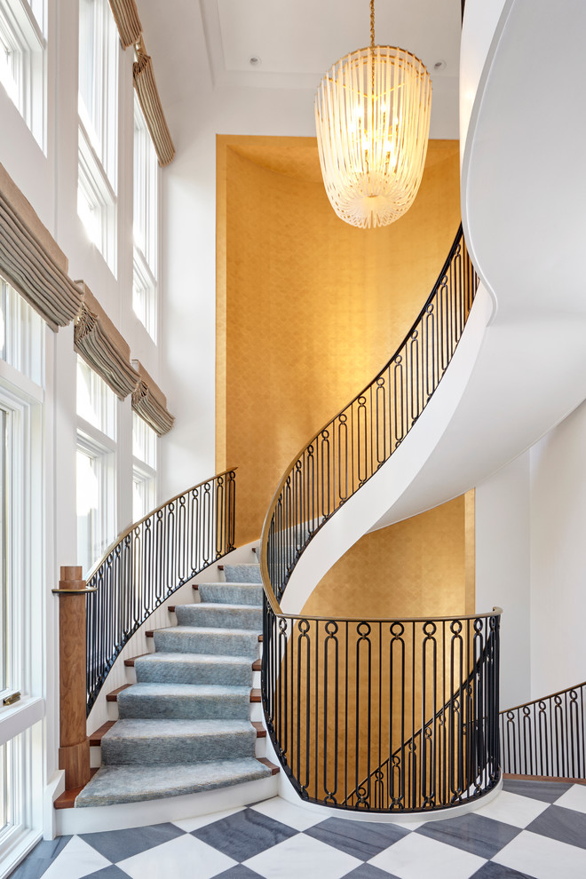 Идея дизайна: большая изогнутая лестница в стиле неоклассика (современная классика) с деревянными ступенями и крашенными деревянными подступенками