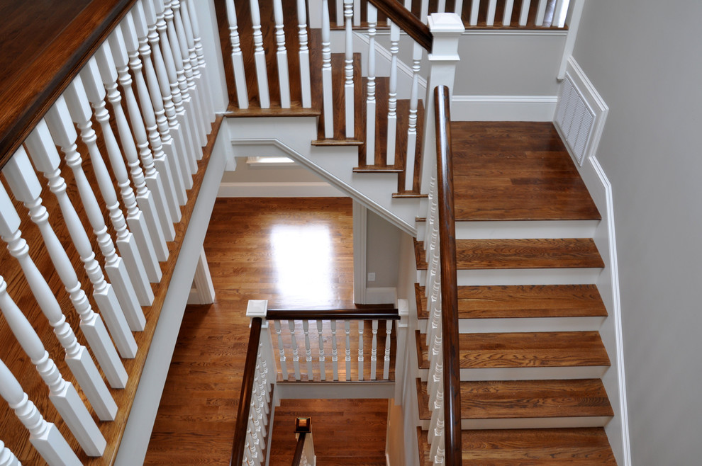 Cette photo montre un grand escalier peint tendance en U avec des marches en bois.