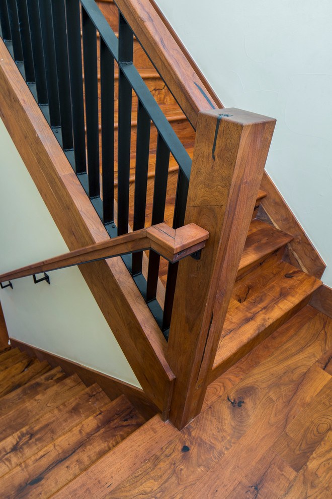 Cette image montre un escalier courbe craftsman de taille moyenne avec des marches en bois, des contremarches en bois et un garde-corps en matériaux mixtes.