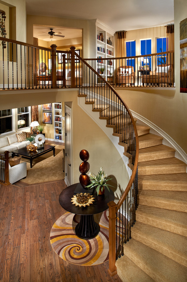 Пример оригинального дизайна: изогнутая лестница в классическом стиле с ступенями с ковровым покрытием и ковровыми подступенками