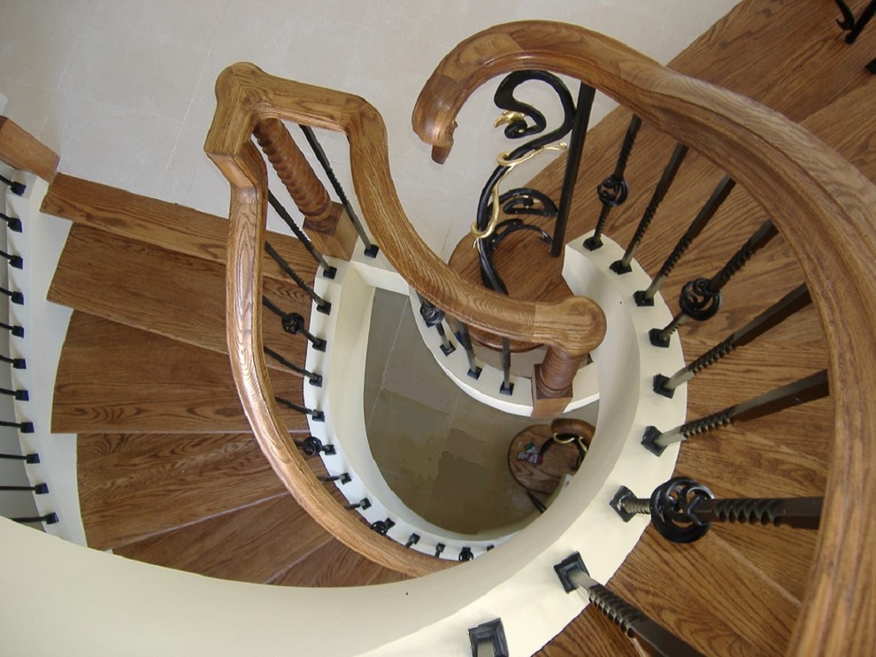 Aménagement d'un grand escalier flottant éclectique avec des marches en bois, des contremarches en bois et un garde-corps en bois.