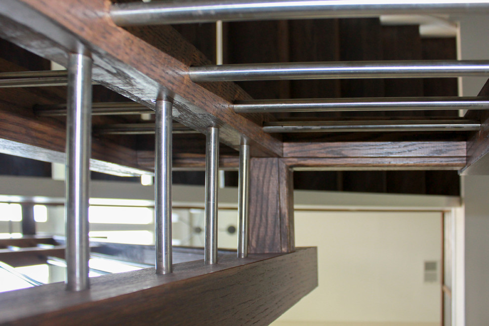 Imagen de escalera suspendida bohemia grande con escalones de madera, contrahuellas de madera y barandilla de madera