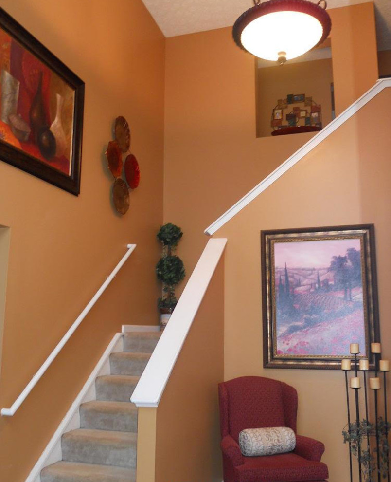 コロンバスにある中くらいなトランジショナルスタイルのおしゃれなかね折れ階段 (カーペット張りの蹴込み板) の写真