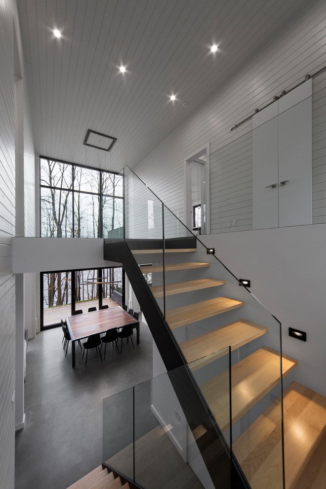 Medium sized contemporary wood u-shaped staircase in Montreal with metal risers.